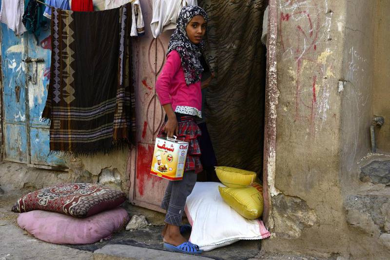 A Yemeni girl receives a food package being delivered by volunteers to her family during the Muslims fasting month of Ramadan at a slum in Sanaa, Yemen. Yahya Arhab / EPA