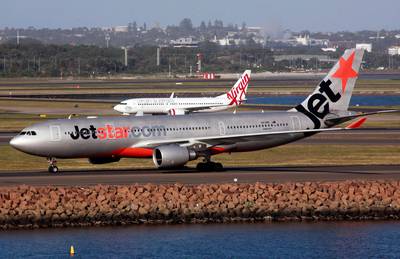 A Jetstar Airways Airbus A330-200 aircraft moves down the runway in front of a Virgin Australia Boeing 737 plane at Sydney Airport in this picture taken April 29, 2013. Virgin Australia Holdings Ltd reported a A$98.1 million ($87.6 million) full-year net loss on Friday, blaming difficult economic conditions, strong competition and one-off costs related to its recently acquired Skywest business. It also said major shareholders Air New Zealand, Etihad Airways and Singapore Airlines had agreed to provide a term loan worth A$90 million. The result contrasts with a well-received full-year net profit of A$6 million reported by rival Qantas Airways Ltd on Thursday. Picture taken April 29, 2013.   REUTERS/David Gray      (AUSTRALIA - Tags: TRANSPORT BUSINESS EMPLOYMENT) - GM1E98U0Q1G01