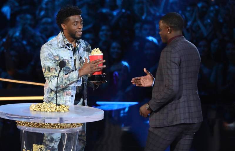 In this Saturday, June 16, 2018, photo, Chadwick Boseman, left, gives his best hero award for his role in "Black Panther" to James Shaw Jr., who is credited with saving lives during a shooting at a Waffle House in Antioch, Tenn., at the MTV Movie and TV Awards at the Barker Hangar on Saturday, June 16, 2018, in Santa Monica, Calif. (Photo by Matt Sayles/Invision/AP)