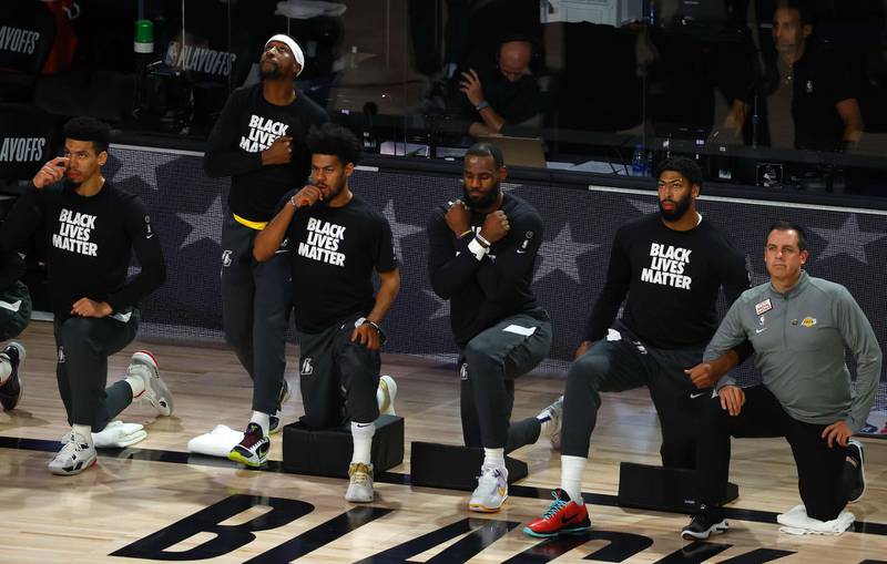 LeBron James and fellow players from the Los Angeles Lakers take a knee during a moment of silence. Getty Images / AFP