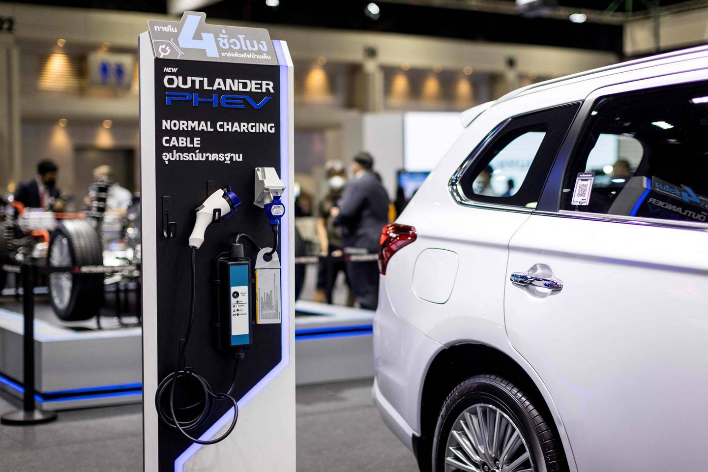 Charging components are displayed next to a Mitsubishi Outlander PHEV at the Thailand International Motor Expo 2021. Photo: AFP