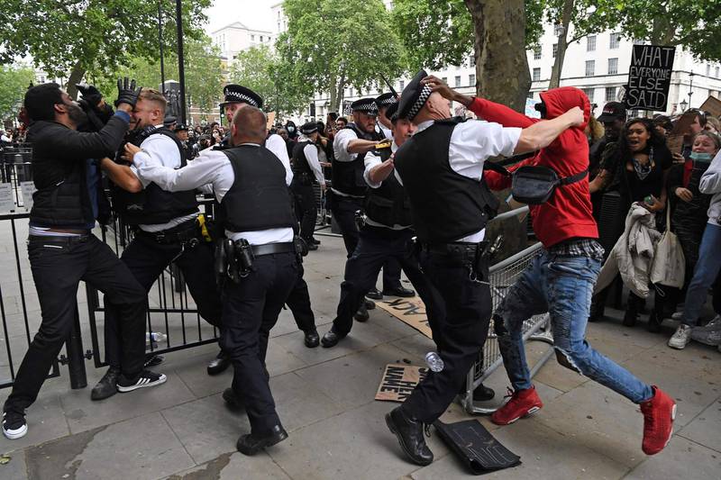 Protestors scuffle with Police officers near the entrance to Downing Street, during an anti-racism demonstration in London.  AFP