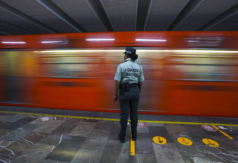 A Mexican National Guard officer watches a train pass at a subway station in Mexico City. The National Guard will be stationed in the city's subway stations after a series of accidents that officials believe are due to sabotage. AP