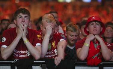 Liverpool supporters react as Real Madrid win the Champions League Final as they look at a large screen at M&S Bank Arena in Liverpool, England, Saturday, May 28, 2022.  The Champions League final soccer match between Liverpool and Real Madrid that is being played at the Stade de France in Saint Denis near Paris.  Madrid won the match 1-0.  (AP Photo / Scott Heppell)