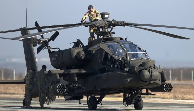 US military personnel check an Apache attack helicopter AH-64 during a technical stop on the tarmac at Traian Vuia International Airport in Timisoara, Romania, on February 24. EPA
