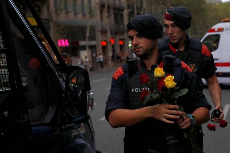 Police officers hold roses given to them by people after a march of unity after the attacks last week, in Barcelona, Spain, August 26, 2017. REUTERS/Juan Medina