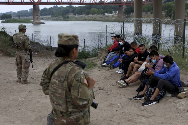 Migrants who had crossed the Rio Grande into the US are apprehended by the National Guard in Eagle Pass, Texas. AP