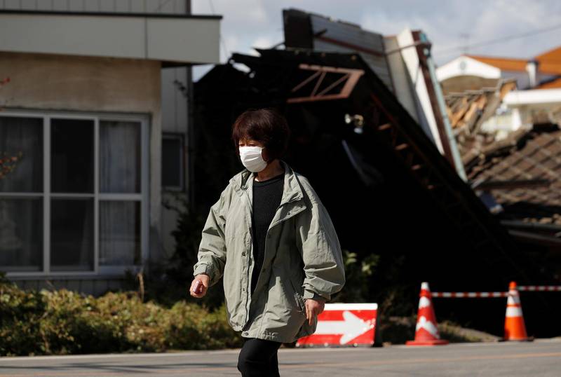 A woman walks near flooded houses, in the aftermath of Typhoon Hagibis, in Koriyama, Fukushima prefecture, Japan. REUTERS