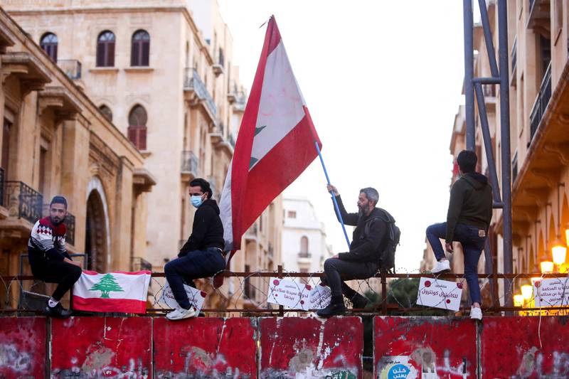 A demonstrator holds a Lebanese flag during a protest in Beirut against the fall in Lebanese currency and mounting economic hardships in March 2021. Reuters