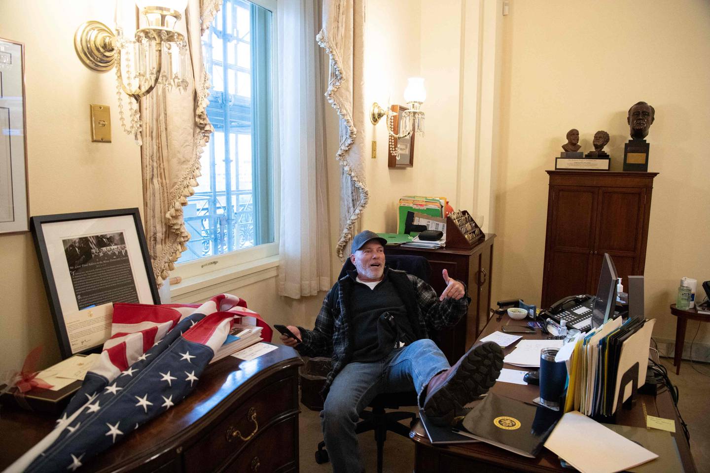 Richard Barnett pose ses pieds sur le bureau de Nancy Pelosi à l'intérieur du Capitole le 6 janvier 2021. AFP