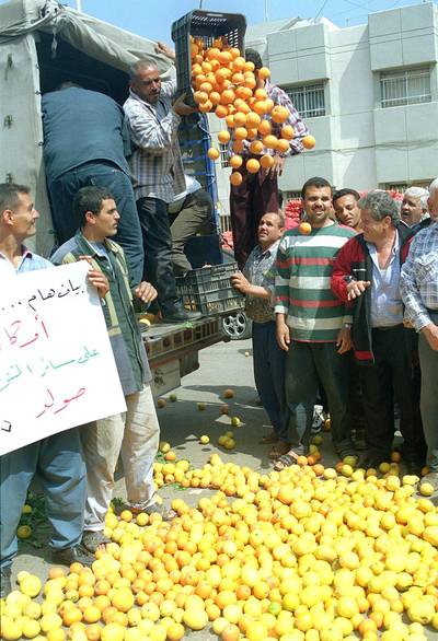 Lebanese farmers dump oranges and lemons in Sidon's main square 02 May 2000 during a protest against a growth in the number of agricultural products, notably citrus fruits, that are illegally entering the country from Syria. About a hundred farmers demonstrated in this
south Lebanon port city saying that the contraband products give unfair competition to Lebanese produce and decrease farmers' prices. (Photo by STR / AFP)