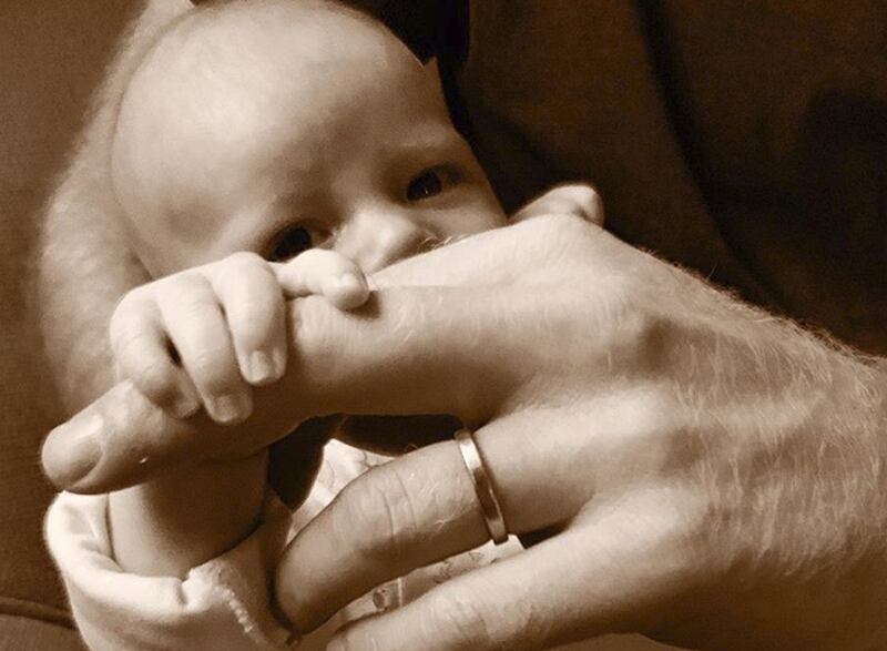 Archie as a baby, holding Prince Harry's hand. Photo: Sussex Royal