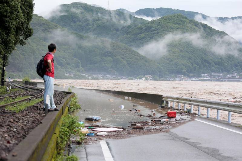 A man looks at the overflowing Kuma river caused by heavy rain in Yatsushiro, Kumamoto prefecture. AFP