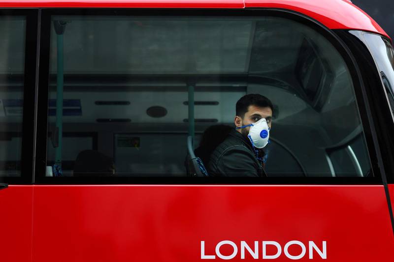 A man wears a mask while sitting on a bus, as the number of coronavirus cases grow around the world, in central London, Britain March 14, 2020.  REUTERS/Dylan Martinez     TPX IMAGES OF THE DAY
