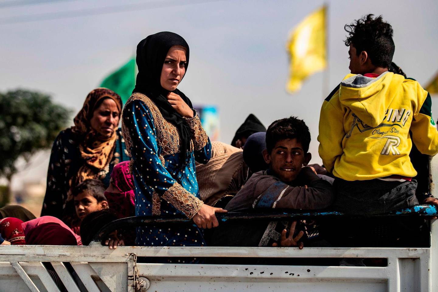 CORRECTION / TOPSHOT - Displaced Syrians sit in the back of a pick up truck as Arab and Kurdish civilians flee amid Turkey's military assault on Kurdish-controlled areas in northeastern Syria, on October 11, 2019 in the town of Tal Tamr in the countryside of Syria's northeastern Hasakeh province. Turkey pressed its deadly offensive against Kurdish targets in Syria as it battled to seize key border towns on the third day of an operation that has forced 100,000 civilians to flee. / AFP / Delil SOULEIMAN
