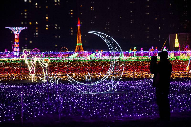 A man takes pictures of illuminated decorations at a lighting display in Handan, Hebei province, China. AFP