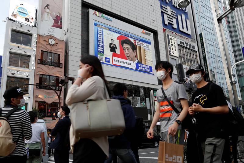 A large screen on a building shows live broadcast of Japan's Prime Minister Shinzo Abe's news conference on the lifting of the state of emergency in Tokyo and the remaining 5 areas still under alert for the coronavirus disease (COVID-19) at Shinjuku district in Tokyo, Japan May 25, 2020.  REUTERS/Issei Kato