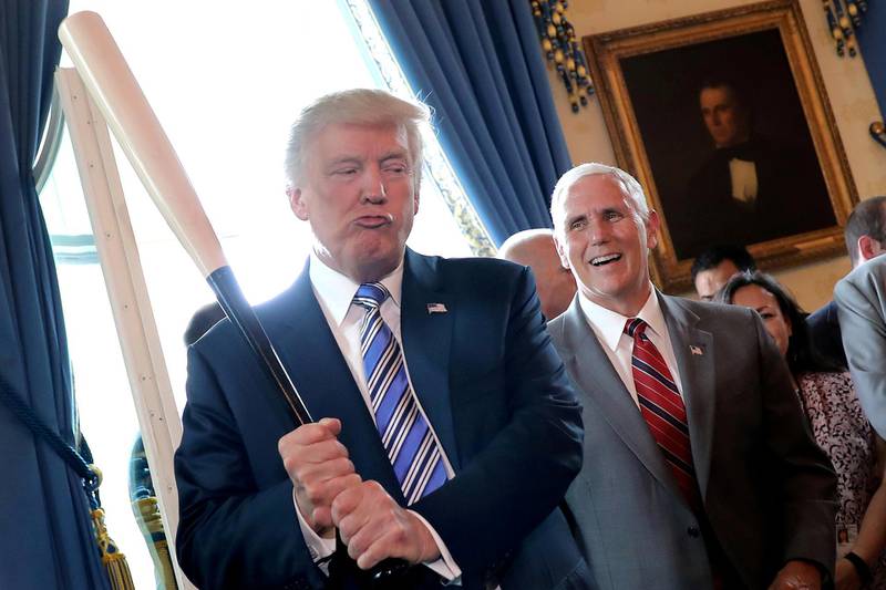 Vice President Mike Pence laughs as President Donald Trump holds a baseball bat as they attend a Made in America product showcase event at the White House in Washington, on July 17, 2017. Reuters