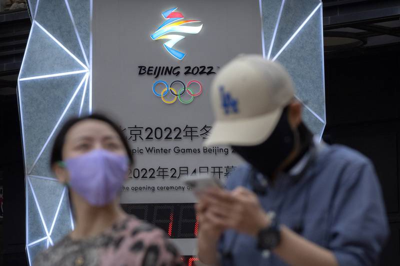 People walk past a countdown clock to the Beijing 2022 Winter Olympics in Beijing. AP 