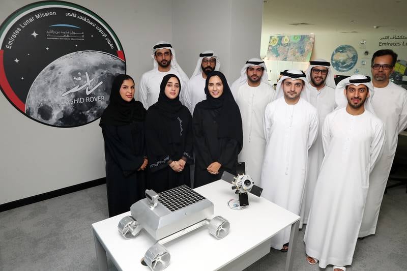 A small team of Emiratis have built the UAE's first mission to the Moon. Here, they are pictured with an old model of the Rashid rover. The flight model has been completed and was shipped to France on June 16 for final testing. Chris Whiteoak / The National 