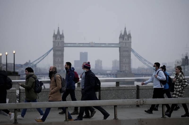 Commuters walk over London Bridge during the morning rush hour. The British government has asked people to return to working in offices as coronavirus restrictions are eased. AP