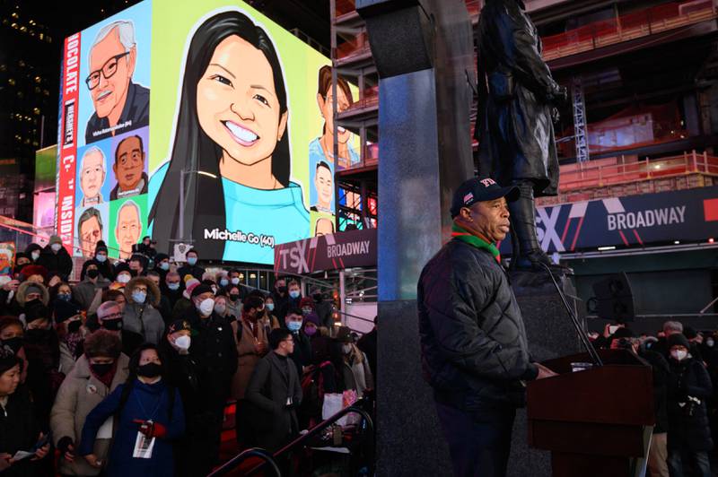 Mayor Eric Adams addresses attendees during a vigil held in honour of Michelle Go, whose image is displayed on a near by building (top, rear), who was killed after being pushed onto subway tracks on January 15, in Times Square, New York on January 18, 2022.  (Photo by Ed JONES  /  AFP)