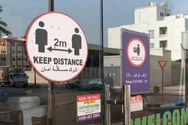 Signs up in shops telling people to keep their distance due to Covid-19 in Al Karama, Dubai. Chris Whiteoak / The National