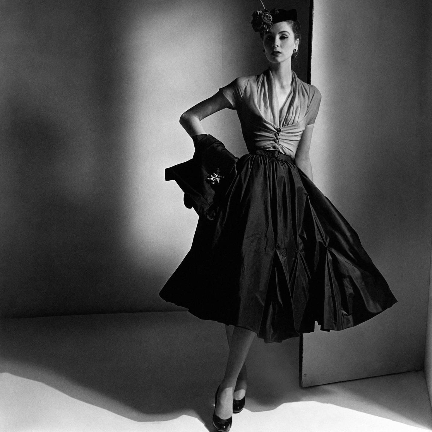 Model Suzy Parker wearing rose chiffon gathered bodice and black tulip-pleat skirt, with pillbox and wrap jacket, by Dior, with a Louis XIV pin. (Photo by Horst P. Horst/Conde Nast via Getty Images)