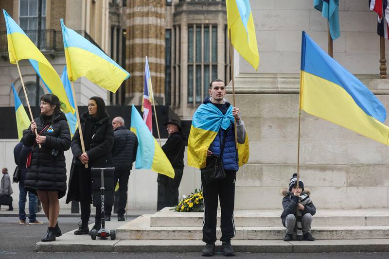 People wave the Ukraine national flag at the Cenotaph memorial in central London. AFP