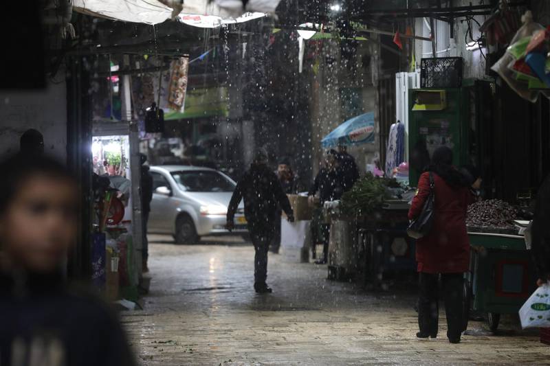 Palestinians walk at a street during a rain storm in the Old City of Nablus, West Bank. EPA