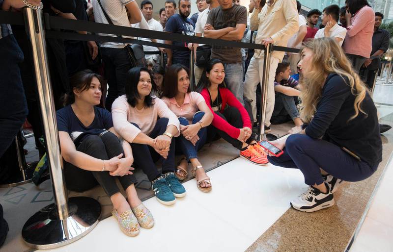 DUBAI, UNITED ARAB EMIRATES, 21 SEPTEMBER 2018 - Apple staff talking to the people waiting in line at Iphone XS launch at Apple store Dubai Mall.  Leslie Pableo for The National
