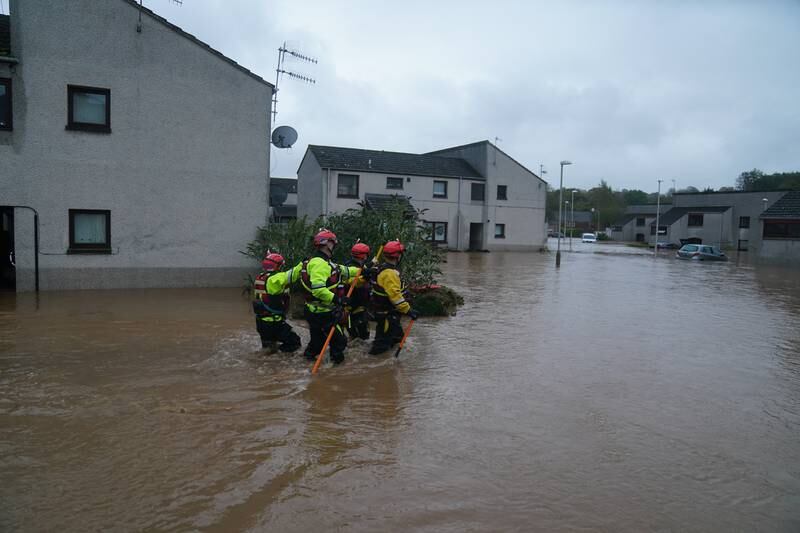 Emergency workers wade through flood water in Brechin, Scotland, as Storm Babet batters the country. Andrew Milligan/PA Wire