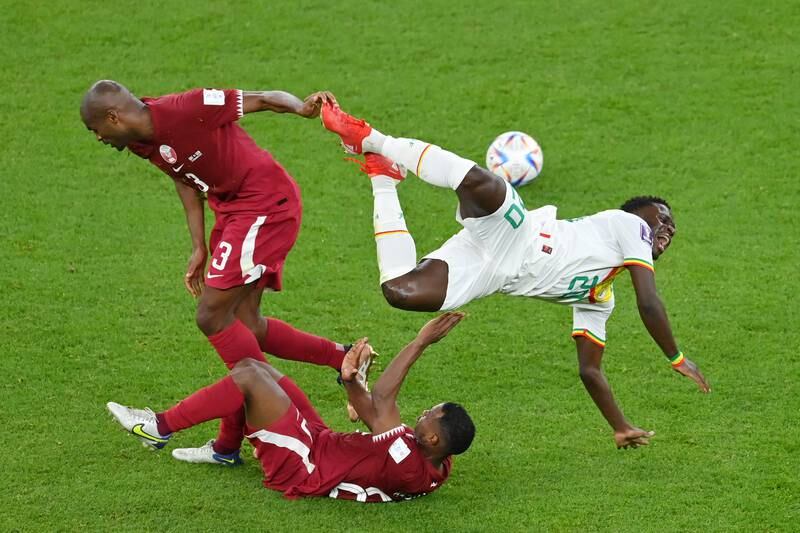 Bamba Dieng of Senegal, right, is challenged by Abdelkarim Hassan and Assim Madibo. Getty Images