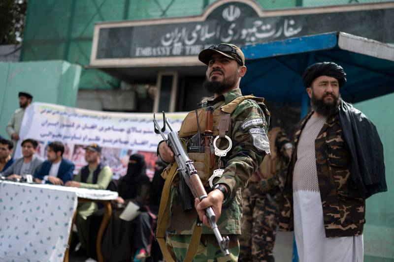 Taliban fighters stand guard at the demonstration in Kabul. AFP