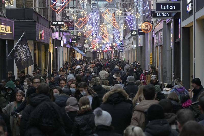 Crowds of people walk down a street on the last Saturday before Christmas in Amsterdam. AP