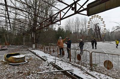 Visitors walk in an abandoned amusement park in the ghost town of Pripyat, not far from Chernobyl nuclear power plant.  AFP