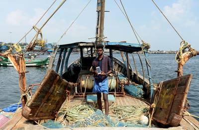 (FILES) In this file photo taken on November 9, 2018 Indian fisherman Satish, 20, poses with his smartphone standing on a fishing vessel at Kasimedu fishing harbour in Chennai. / AFP / ARUN SANKAR
