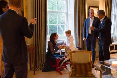 Mr Obama talks with the UK's Prince William, Duke of Cambridge, as Catherine, Duchess of Cambridge, plays with Prince George and Michelle Obama talks with Prince Henry at Kensington Palace, London, in 2016. The White House / Getty Images