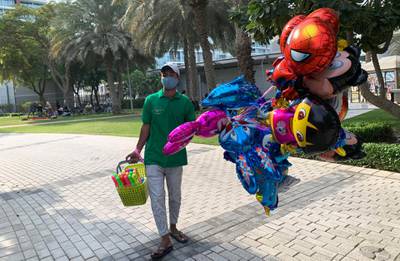 DUBAI, UNITED ARAB EMIRATES , December 25 – 2020 :- Balloon seller on the Christmas day in Zabeel park in Dubai. ( Pawan Singh / The National ) For News/Standalone/Online/Instagram