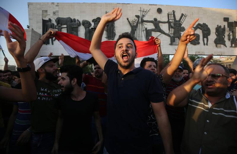 Iraqis holding national flags demonstrate against unemployment in the capital Baghdad's Tahrir Square. AFP