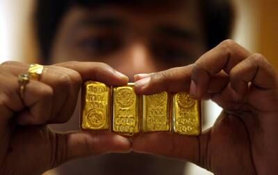 FILE PHOTO: A salesman displays gold bars inside a jewellery shop on the occasion of the Akshaya Tritiya festival in the southern Indian city of Hyderabad May 6, 2011. Gold jewellery is a popular gift at marriages and festivals in India. REUTERS/Krishnendu Halder/File Photo