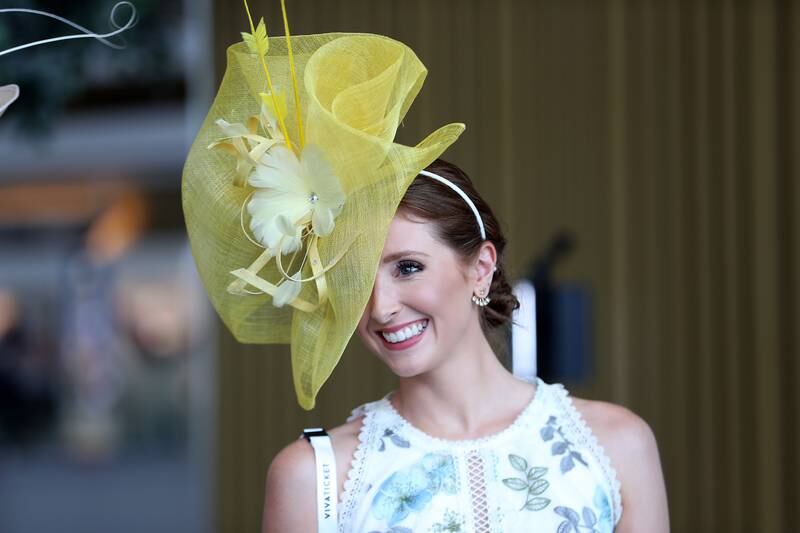 A woman wears an intricate yellow hat and floral dress for the Dubai World Cup. Pawan Singh / The National