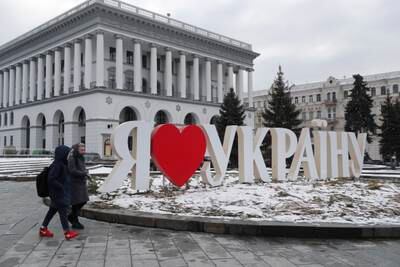 People walk past a sign reading 'I Love Ukraine' in the central square in Kiev. EPA