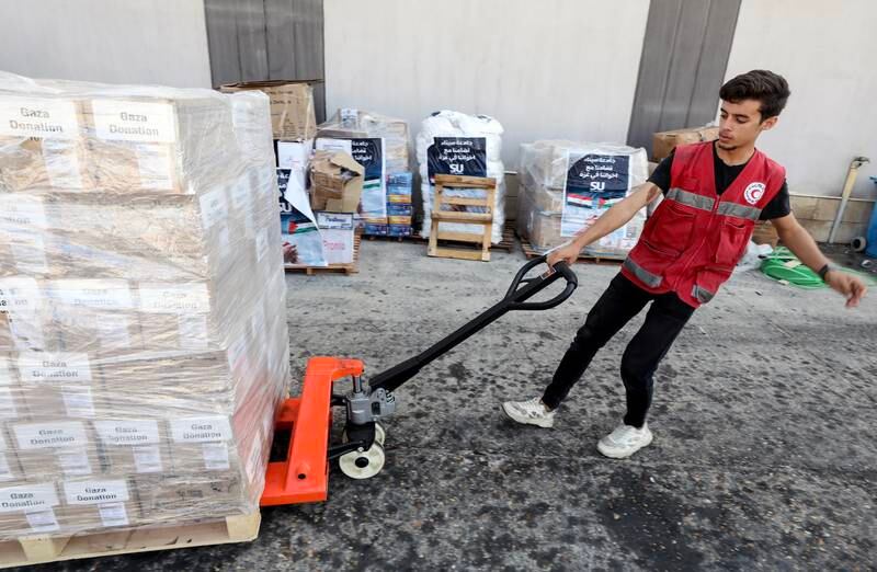 A Red Crescent Society staff member handles packages of humanitarian aid bound for Palestinians in the Gaza Strip, at a warehouse in Arish, Egypt. EPA