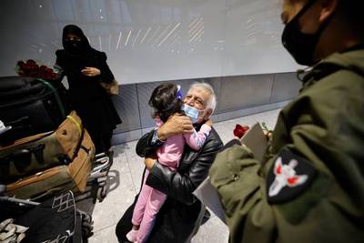 Relatives embrace as they arrive from the US at Heathrow's Terminal 5 in west London.