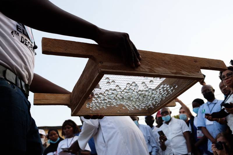 An election official carries marbles in a wire tray to an audience of election observers in Banjul. Gambia. The voting will be closely watched as a test of the democratic transition in the country. AFP