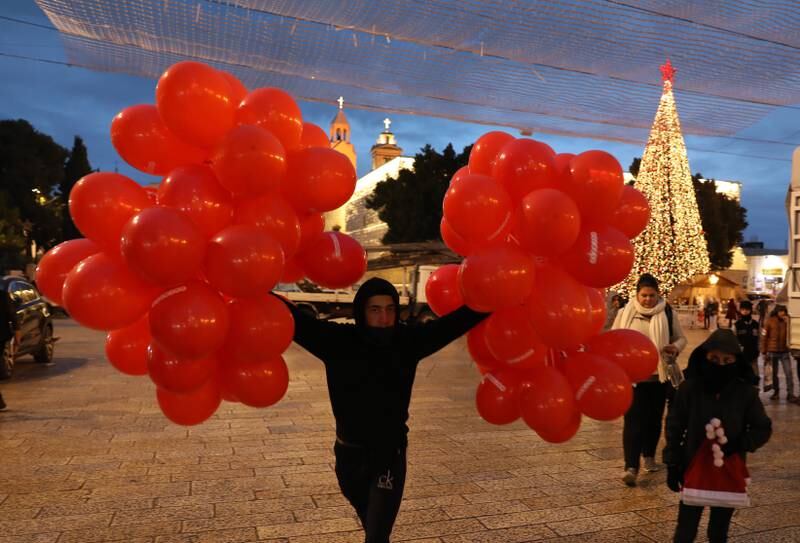 A street vendor selling festive balloons at Manger Square, next to the Church of the Nativity. The church is administered jointly by the Greek Orthodox, Roman Catholic, Armenian Apostolic, and Syriac Orthodox churches. EPA