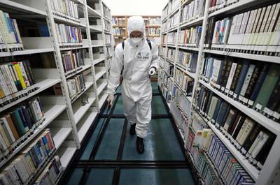 An army soldier sprays disinfectant to curb the spread of the coronavirus at a library in Daegu, South Korea. Yonhap via AP