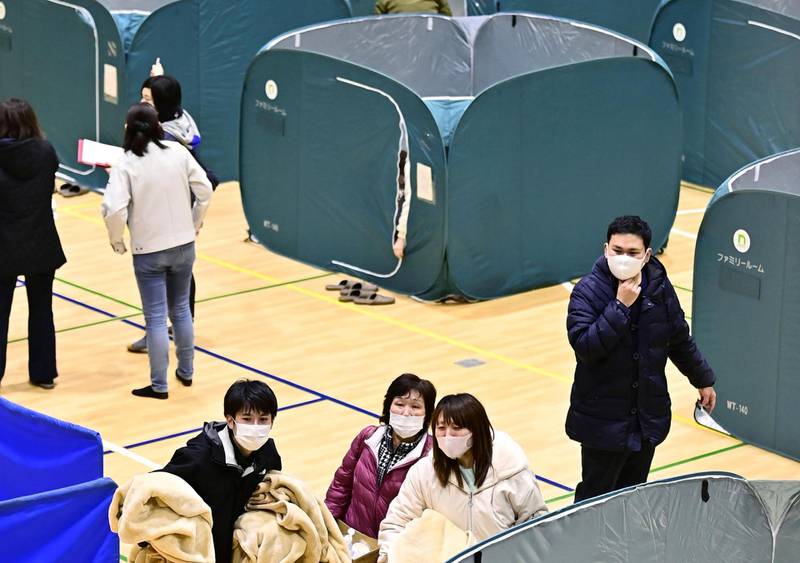 People are seen at a temporary evacuation center using partition for social distancing following the coronavirus disease (COVID-19) outbreak, in Soma, Fukushima Prefecture after a strong earthquake shook northeastern Japan. Reuters