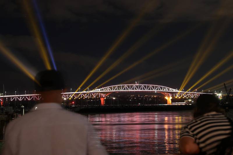 Auckland Harbour Bridge light show beams colorful lights across the sky in New Zealand. Getty Images